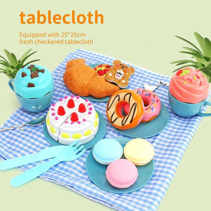 Pretend desserts, plates, and utensils arranged on a blue checkered picnic tablecloth