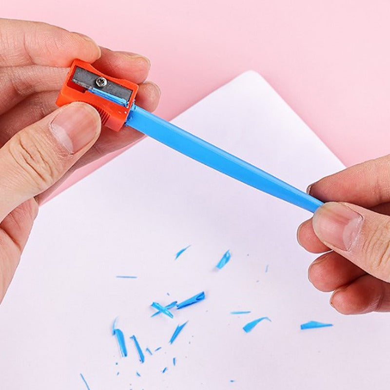 Blue crayon being sharpened over paper with an orange sharpener