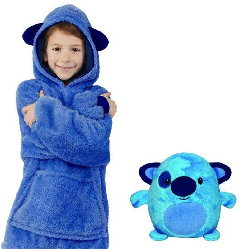 Child wearing the blue creature hoodie beside the blue plush toy with rounded ears.