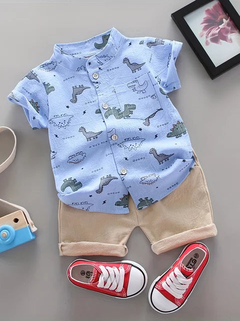 Blue dinosaur-print short-sleeve shirt and beige shorts shown as a coordinated set
