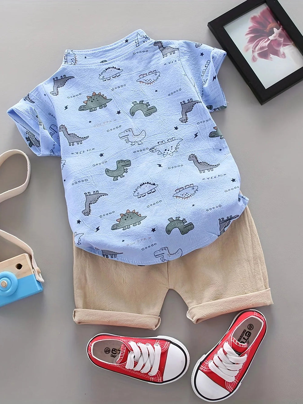 Back view of the blue dinosaur-print shirt paired with beige shorts