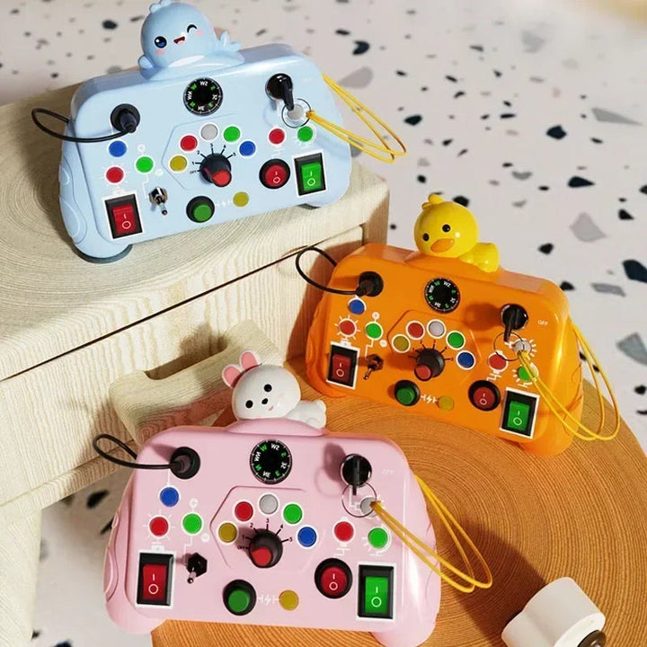 Light blue, orange, and pink activity boards with character toppers and colorful controls