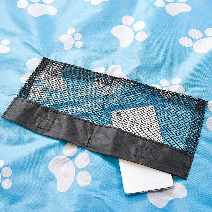 Black mesh pocket on the blue paw-print mat with a phone partly tucked inside.
