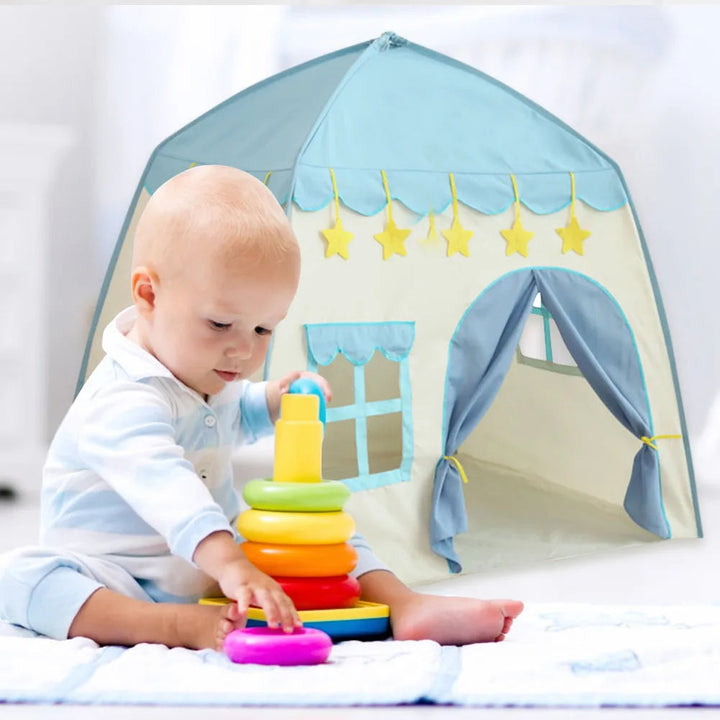 Child playing with stacking rings in front of a blue castle play tent