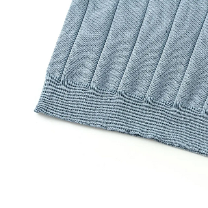 Blue polo shirt hem with ribbed trim beneath the vertical knit pattern