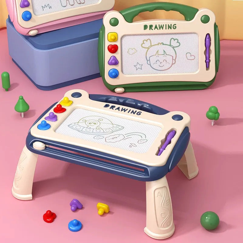 Blue drawing board on four legs beside green and pink handheld boards