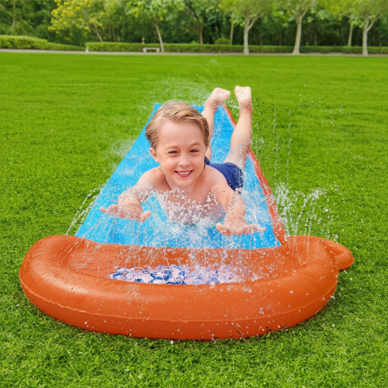 Child sliding through water spray toward the orange end bumper