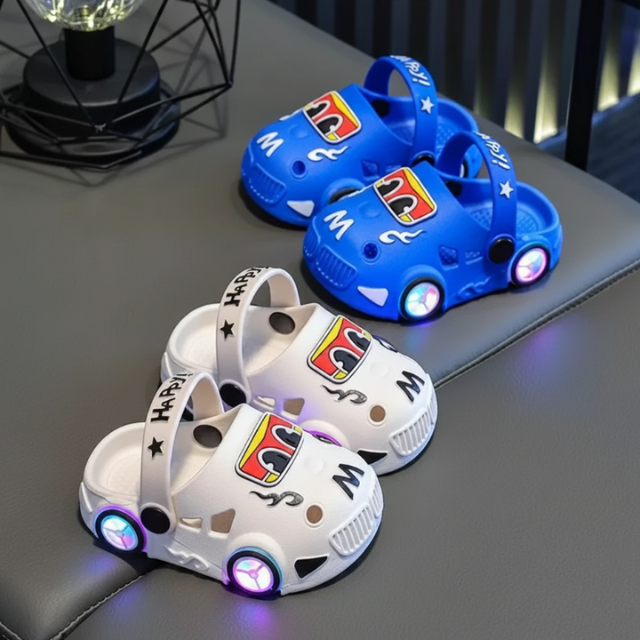 Blue and white car slipper pairs with glowing wheel-shaped lights on a bench.