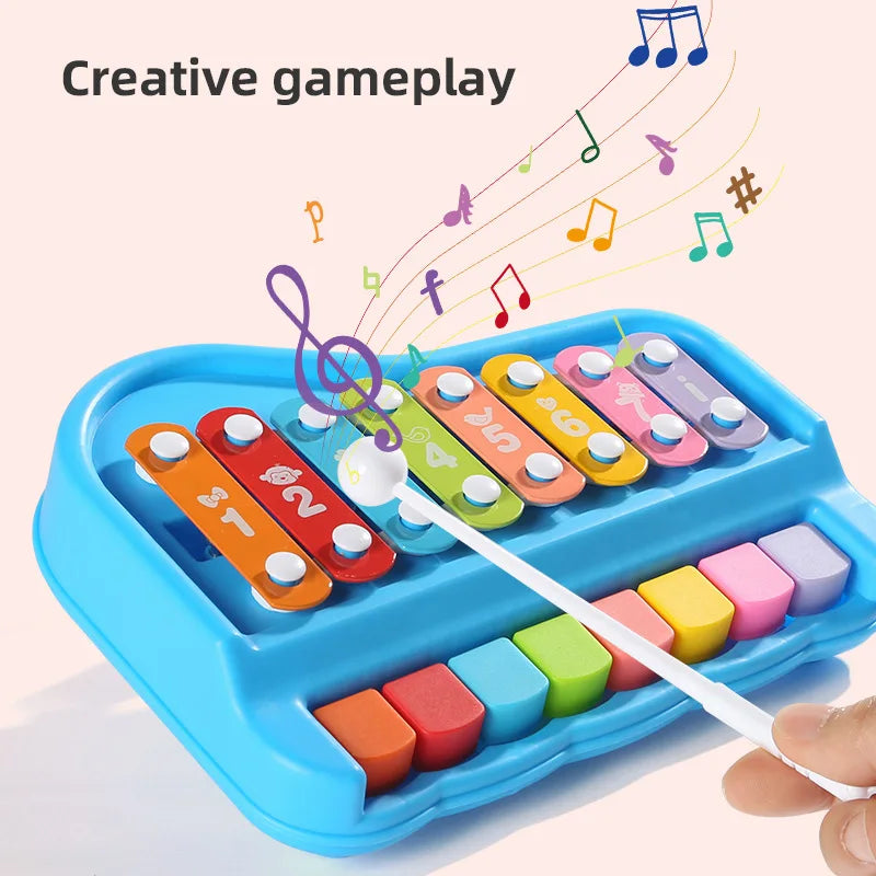 Blue xylophone and piano toy being played with a white mallet