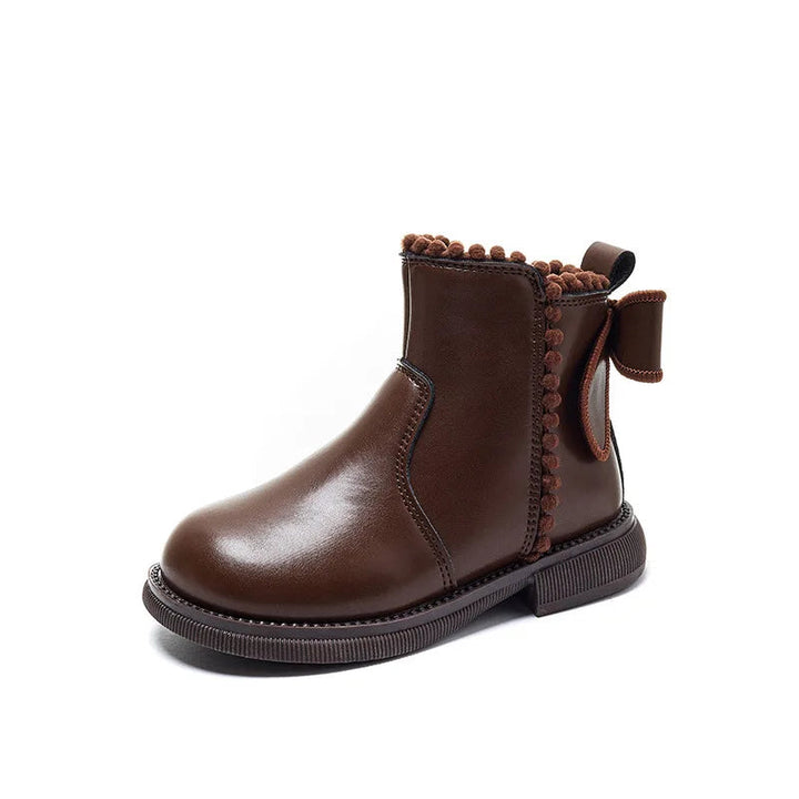Brown ankle boot showing its rounded toe, decorative trim, and back bow on a white background