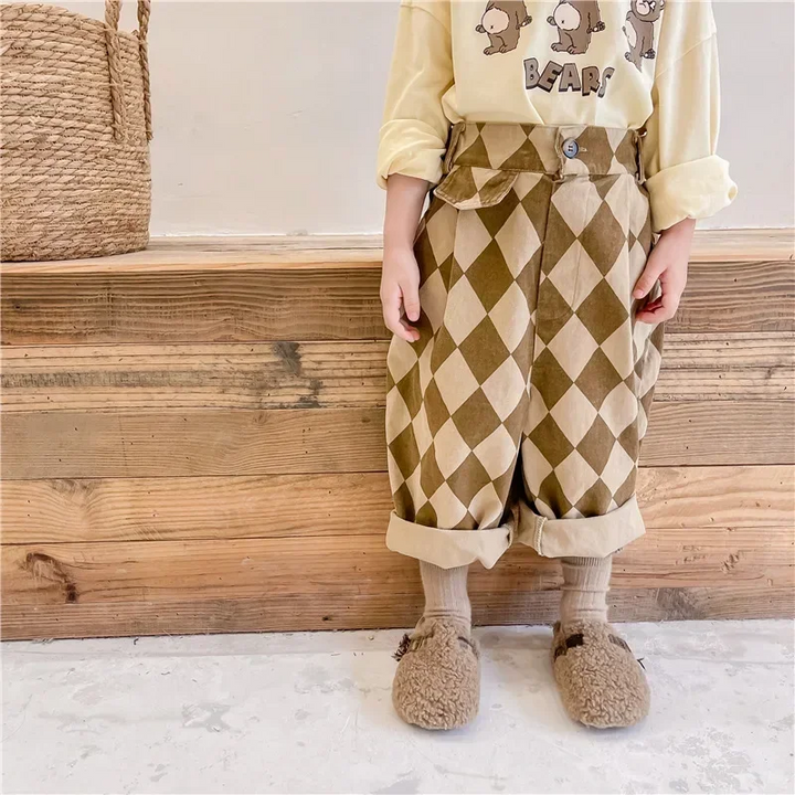 Child wearing brown argyle pants with turned-up cuffs and a light-colored top