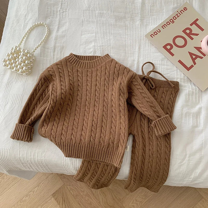 Brown cable-knit sweater and matching drawstring pants laid out together