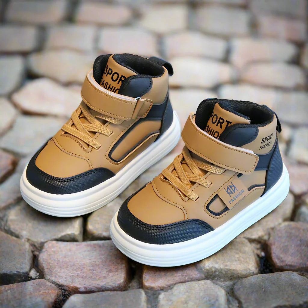 Pair of brown high-top sneakers with ankle straps and black trim on cobblestones