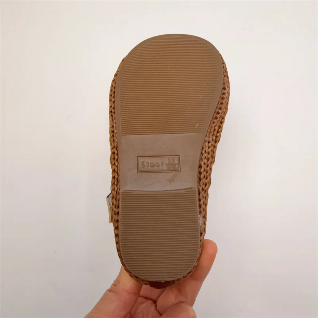 Underside of a brown Mary Jane flat showing the ridged rubber sole