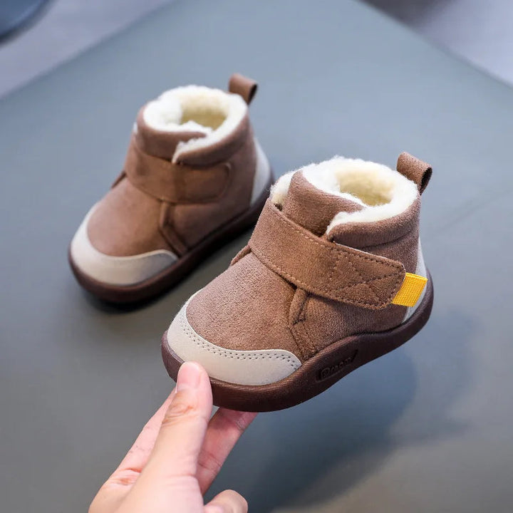 Brown plush-lined winter boots with one boot held at the toe to show its side