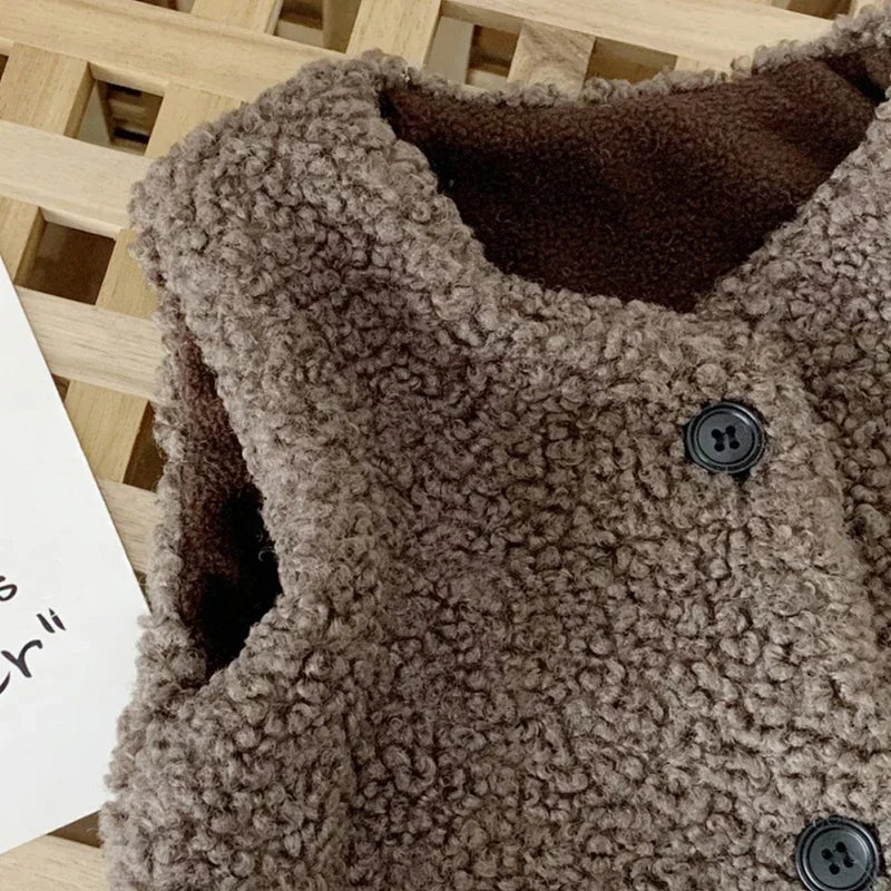 Close-up of a brown plush vest showing its rounded neckline and dark front buttons