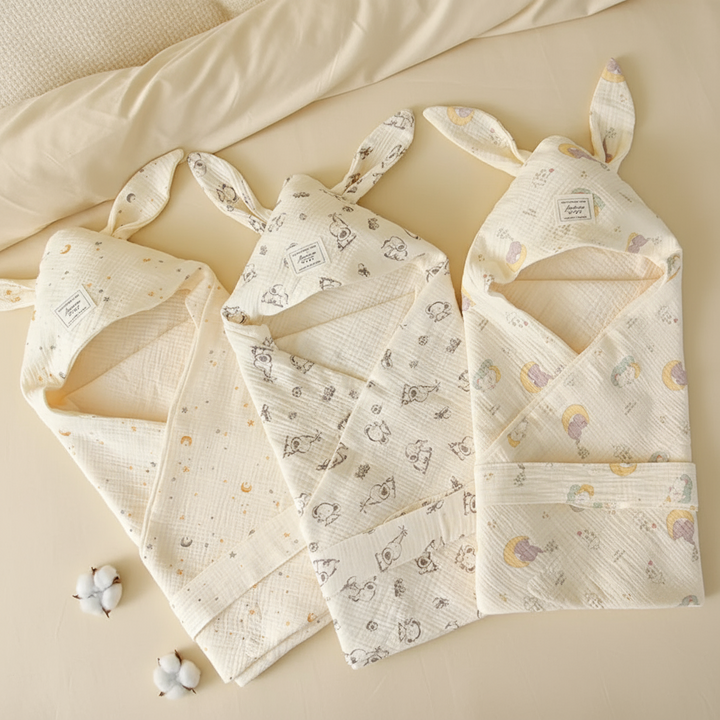 Three bunny-ear swaddle blankets in star, bunny, and moon prints