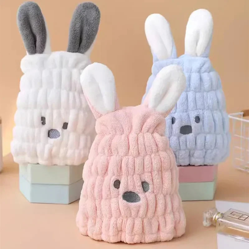 Pink, white, and blue bunny hair-drying caps with plush ears and stitched faces