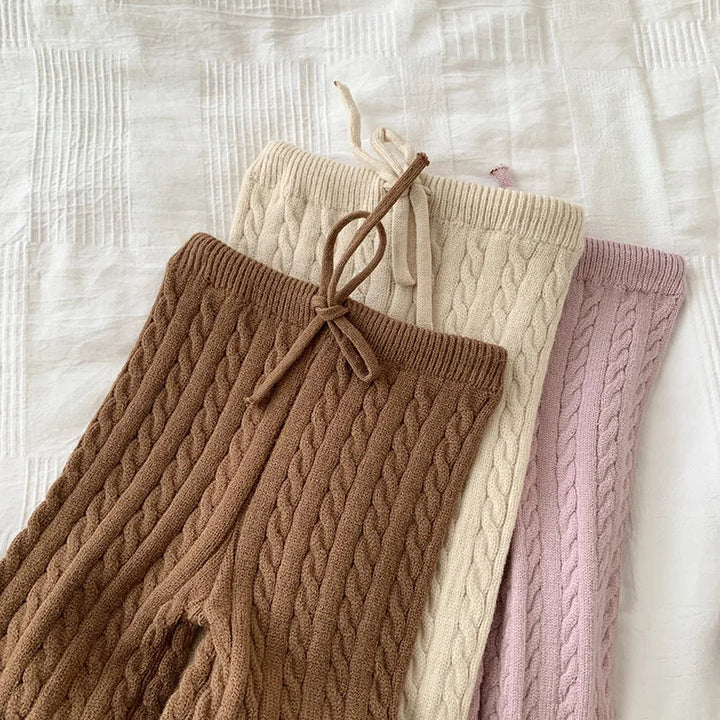 Brown, beige, and pink cable-knit pants showing drawstring waistbands