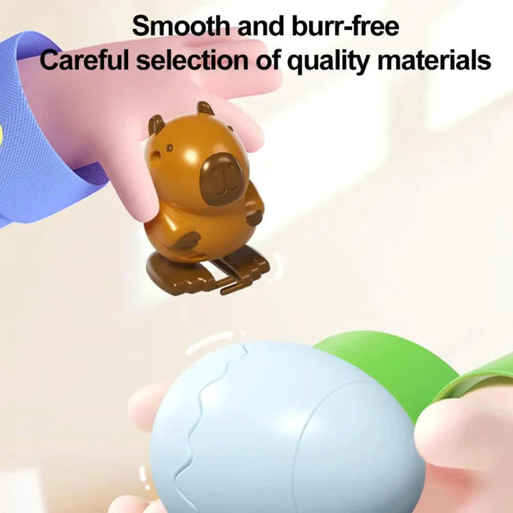 Close-up of a capybara figure and a pale blue egg shell held in hands
