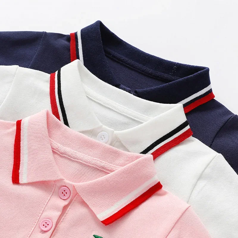Close-up of striped polo collars and matching buttons on pink, white and navy blue dresses.