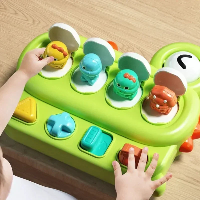 Child exploring the colorful controls and pop-up animals on a green activity toy