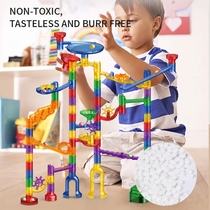 Child playing with a colorful marble run featuring ramps and collection funnels