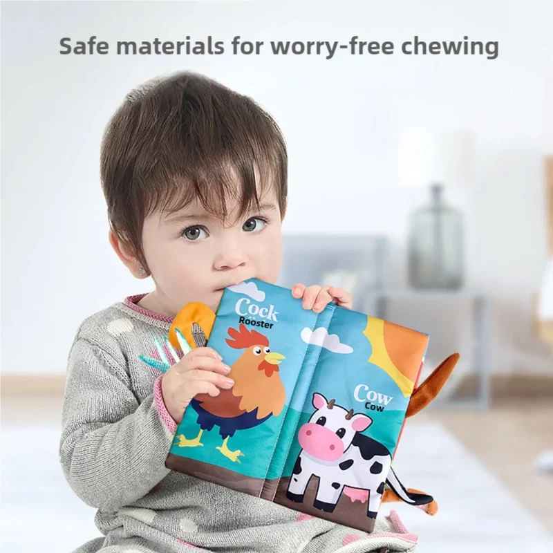 Child holding an open cloth book with rooster and cow illustrations