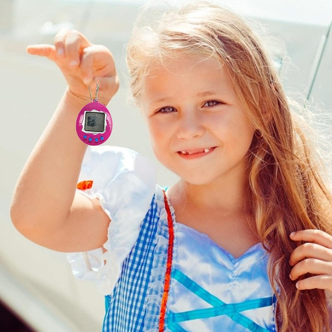 Child holding a pink egg-shaped digital pet toy by its ball chain.