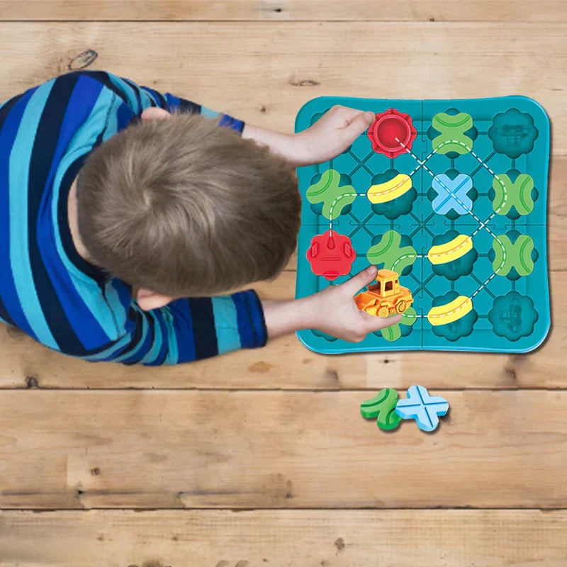 Child playing with road pieces and an orange vehicle on a teal puzzle board on a wooden floor