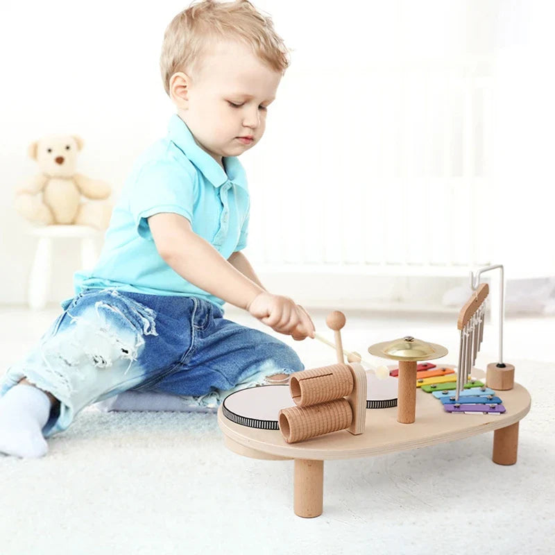 Child playing a wooden music playset with a mallet