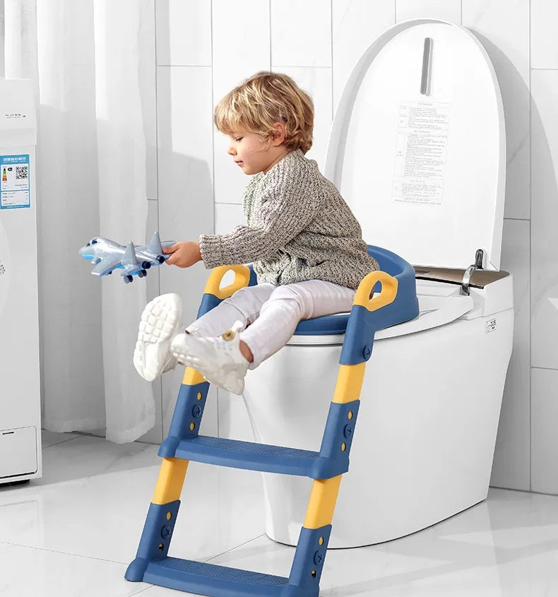 Child seated on a blue toilet training seat with yellow handles and an attached step