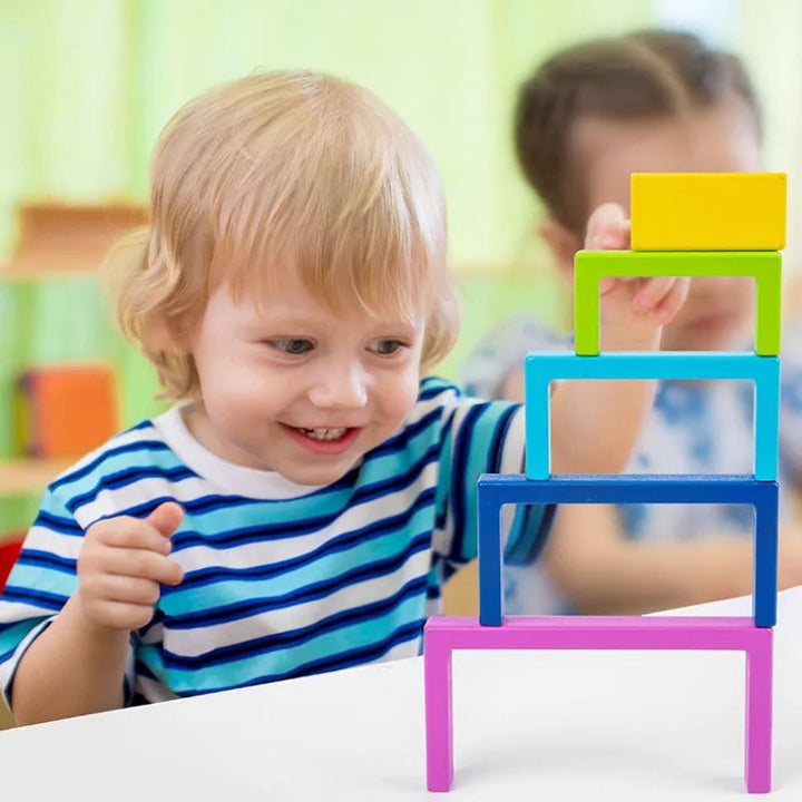 Child stacking colorful rectangular wooden frames into a tower