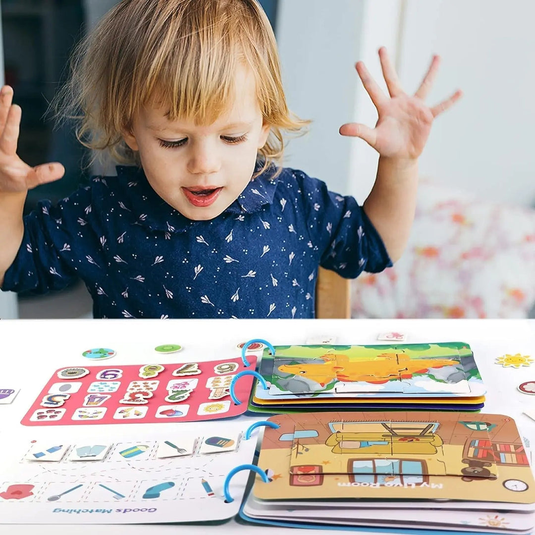 Child seated at a table with open activity books and colorful matching pieces