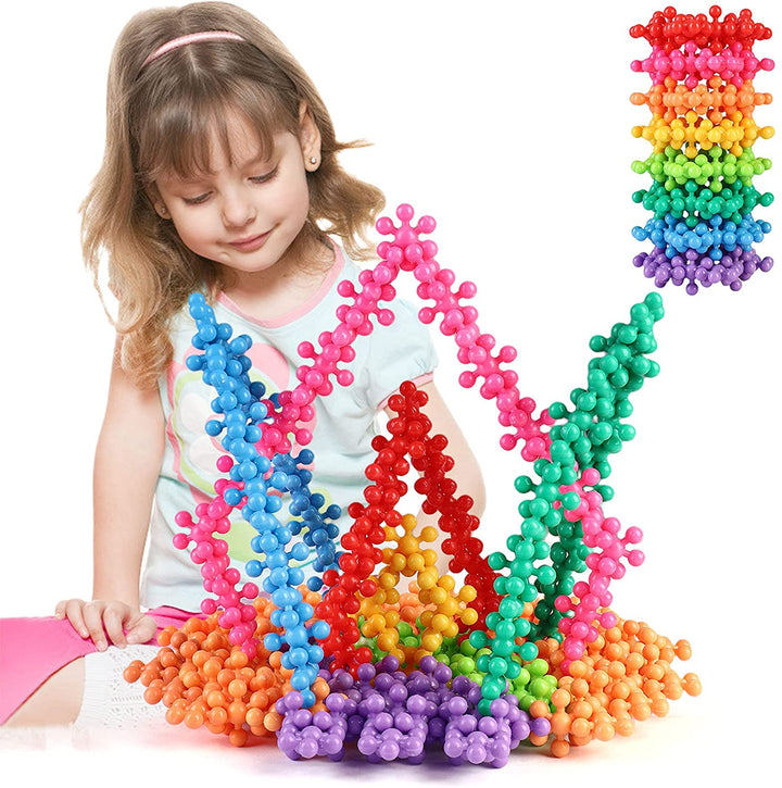 Child beside a colorful 3D structure made from interlocking snowflake blocks