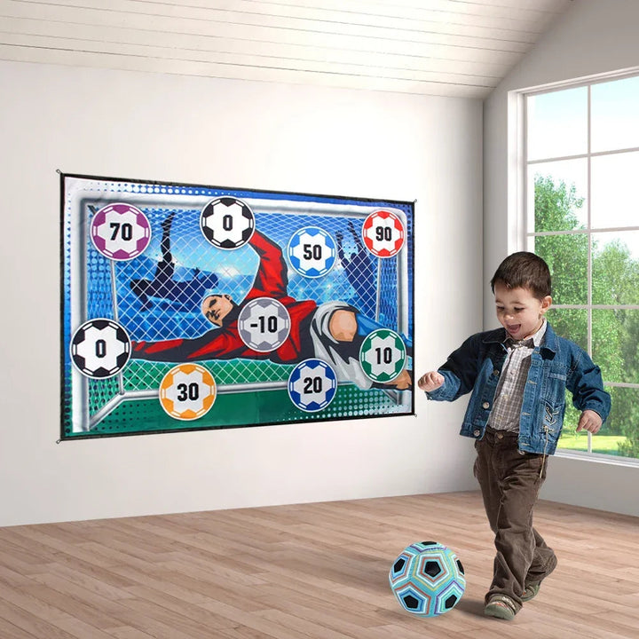 Child with a blue soccer ball beside a wall-mounted goalkeeper target