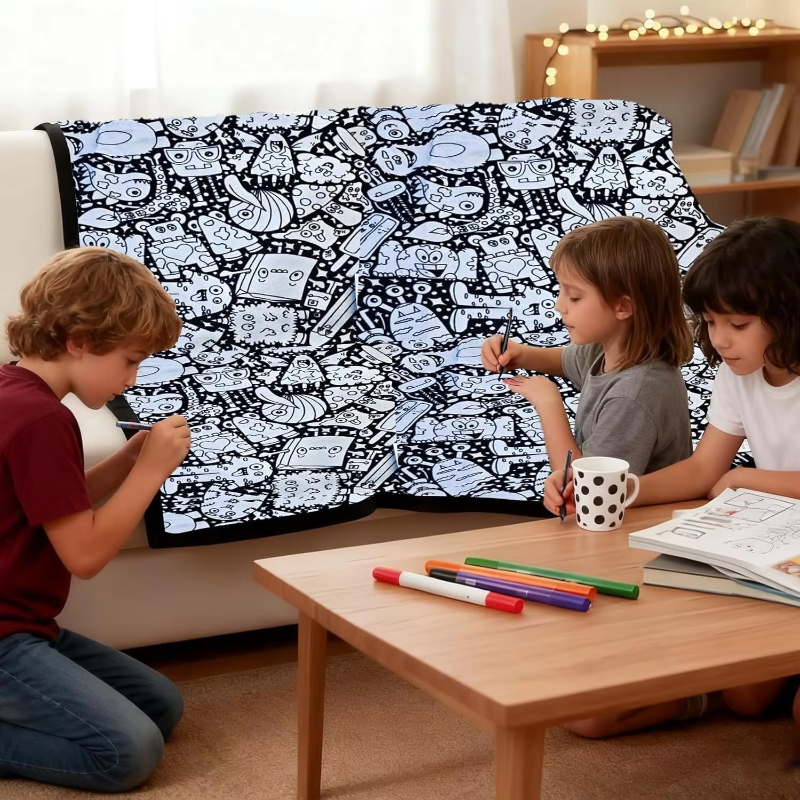 Children coloring an illustrated mat draped over a sofa