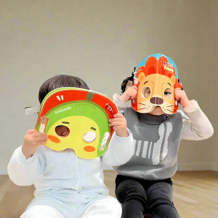 Two children holding avocado and lion cloth book pages in front of their faces.