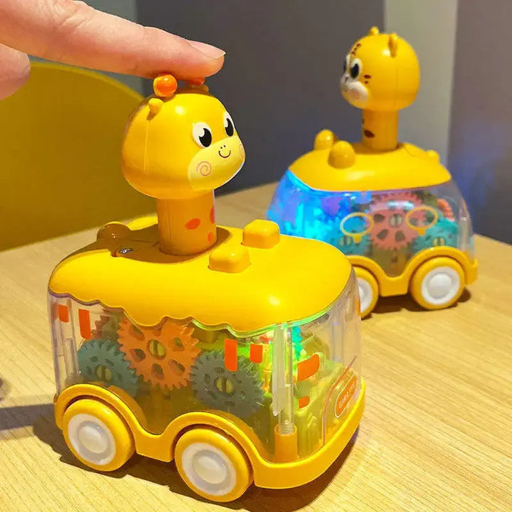 Hand pressing the animal-shaped top of a clear toy car with colorful gears