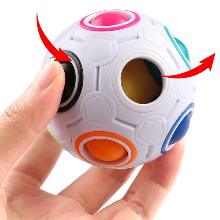 Hand pressing a colored ball into a white puzzle sphere, with arrows showing movement toward an empty opening