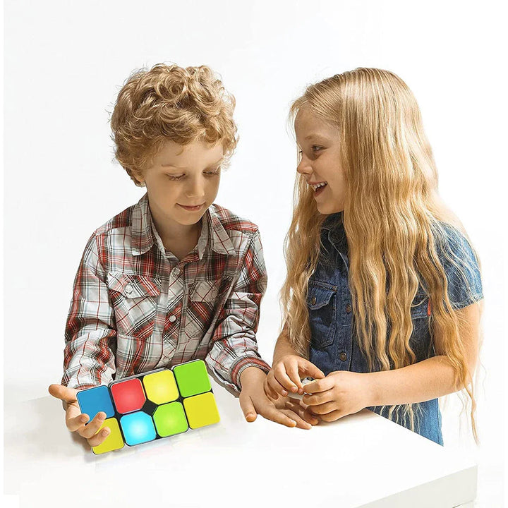 Two children exploring a handheld color-matching puzzle together at a table