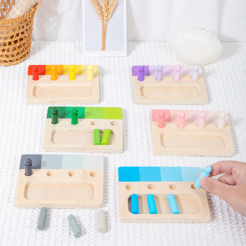 Wooden color-sorting boards with matching pegs and a hand holding a blue peg
