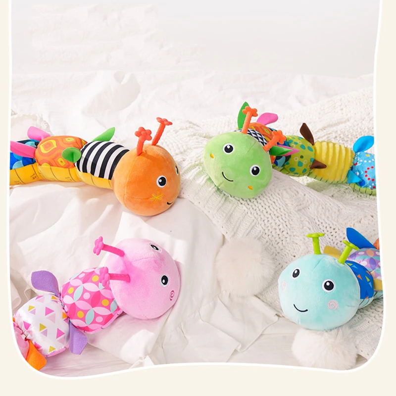Close view of four caterpillar rattles with colorful faces and patterned fabric bodies