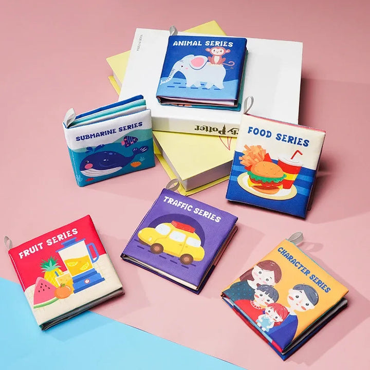 Six colorful cloth baby book themes featuring animals, sea life, family, vehicles, fruit and food