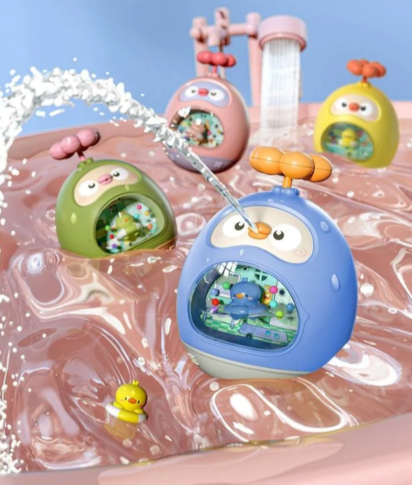 Blue, pink, green, and yellow duck-shaped bath toys with water streams over a pink tray
