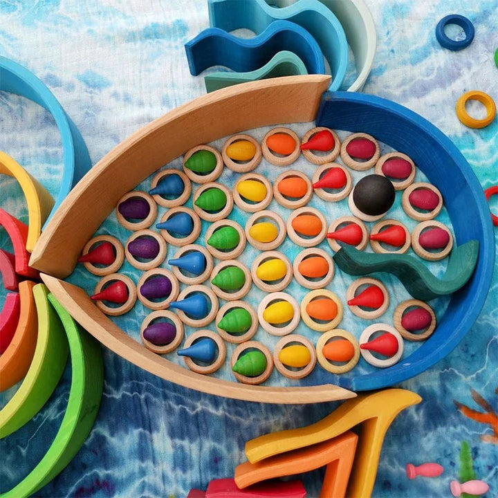Colorful wooden loose parts arranged within a fish-shaped outline