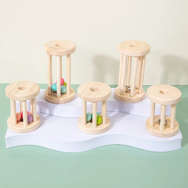 Five wooden cage rattles with balls or bells on a tiered white stand