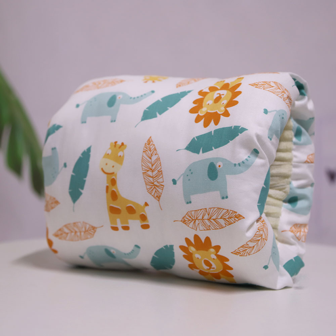 Nursing pillow printed with lions, giraffes, elephants, and leaves.