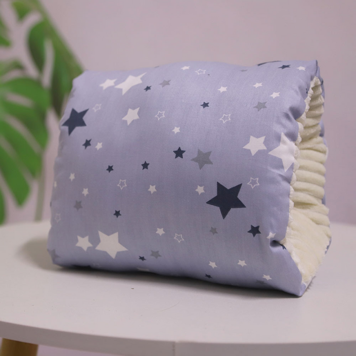 Gray nursing pillow patterned with small and large stars.