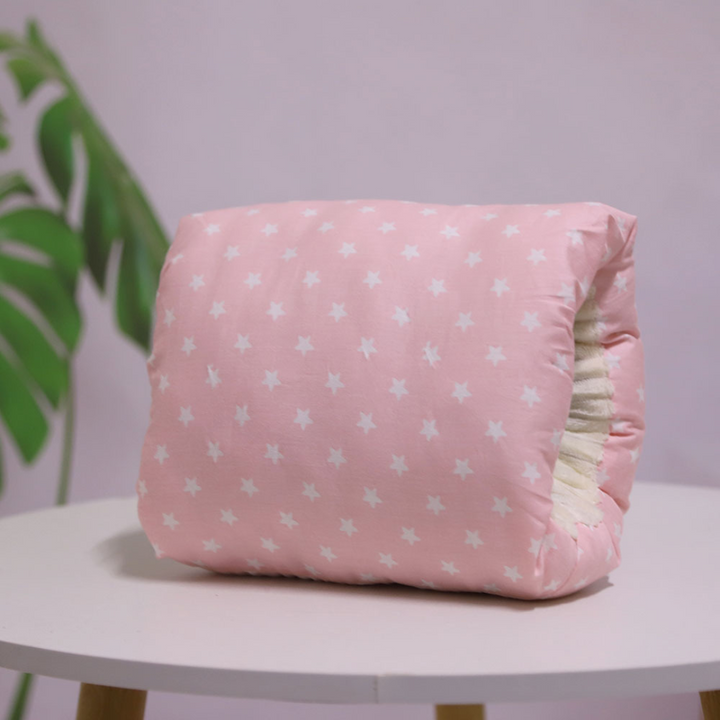 Pink nursing pillow with white stars and an arm opening.